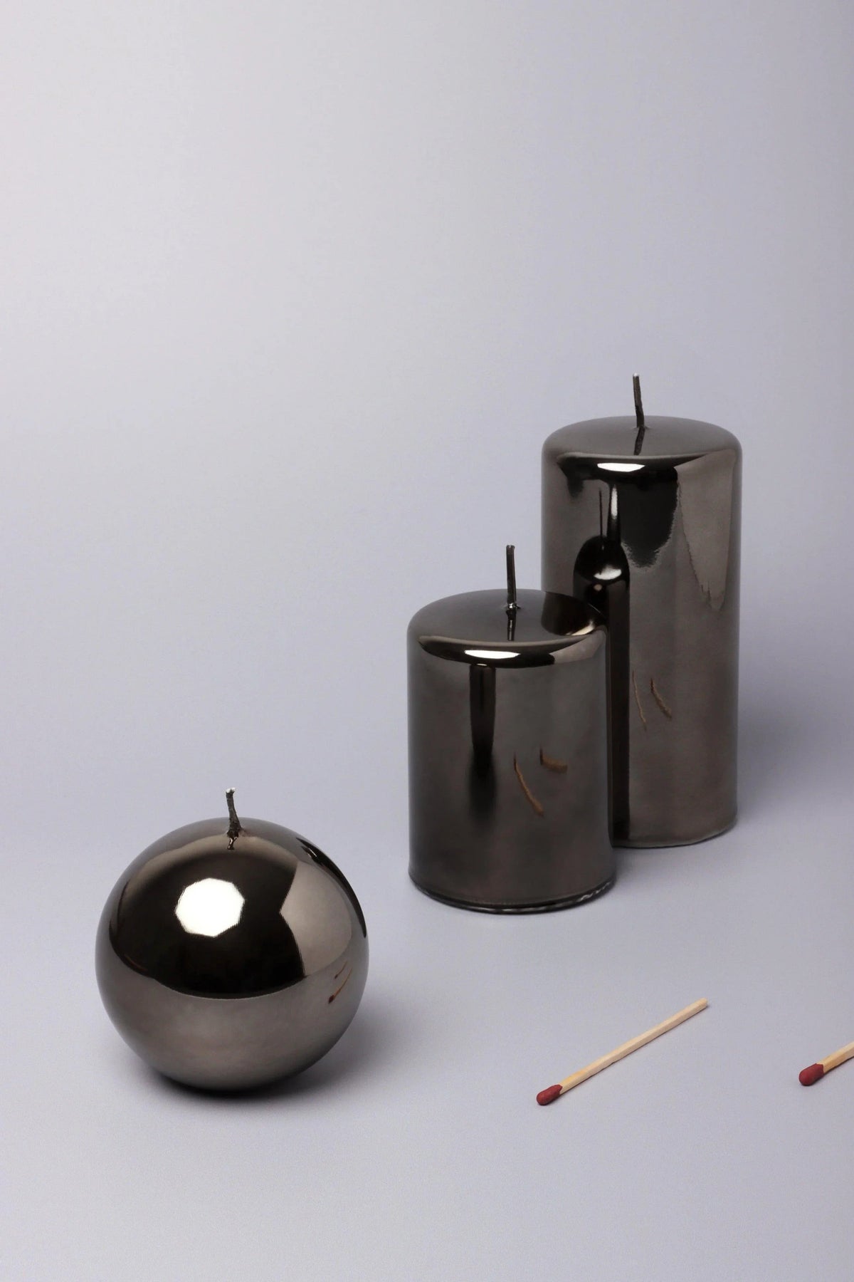 A styled mantelpiece detail — Clarae Reflet mirror-glass pillar and ball candle in grey mist, set against a fireplace surround | G Decor
