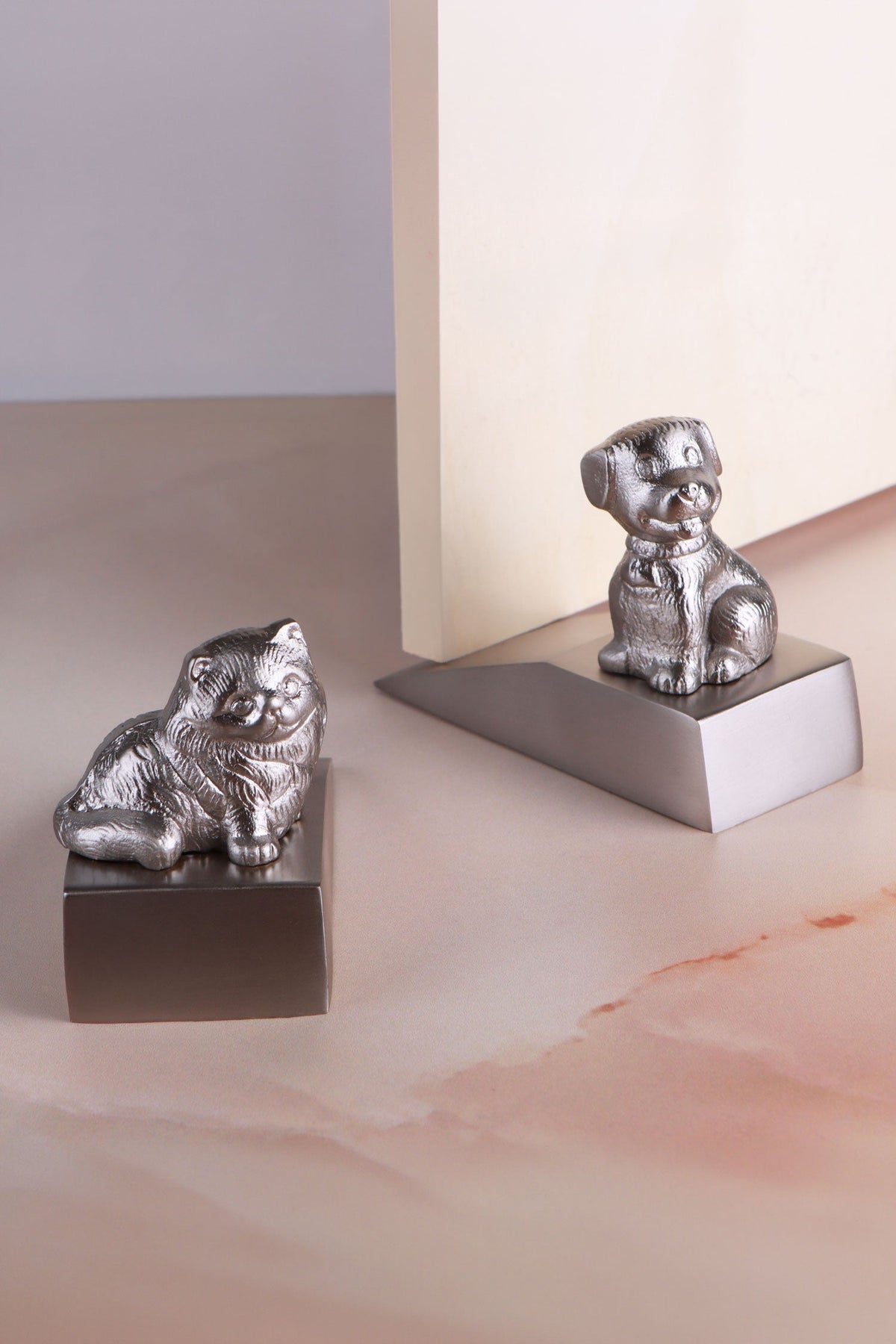 Companion cat and dog door stoppers in chrome