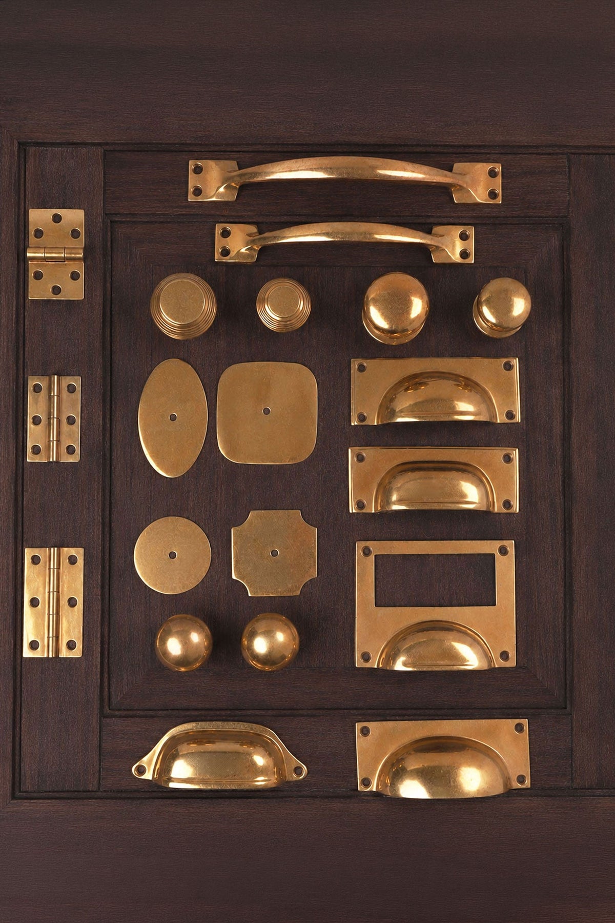 The wider solid aged brass range — knobs, cup pulls, hinges and backplates