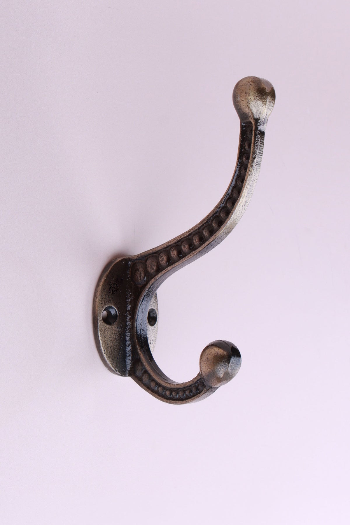 Beaded Double Hook: cast iron double hook with a row of raised beads along both arms and ball ends, on an oval back plate, antique brass finish