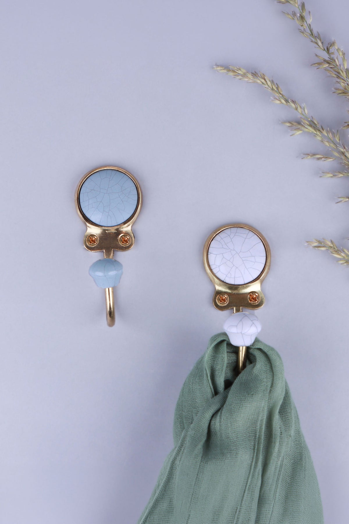 Blue-grey and white crackle glaze ceramic coat hooks with matching knobs, a green scarf hanging from the white hook