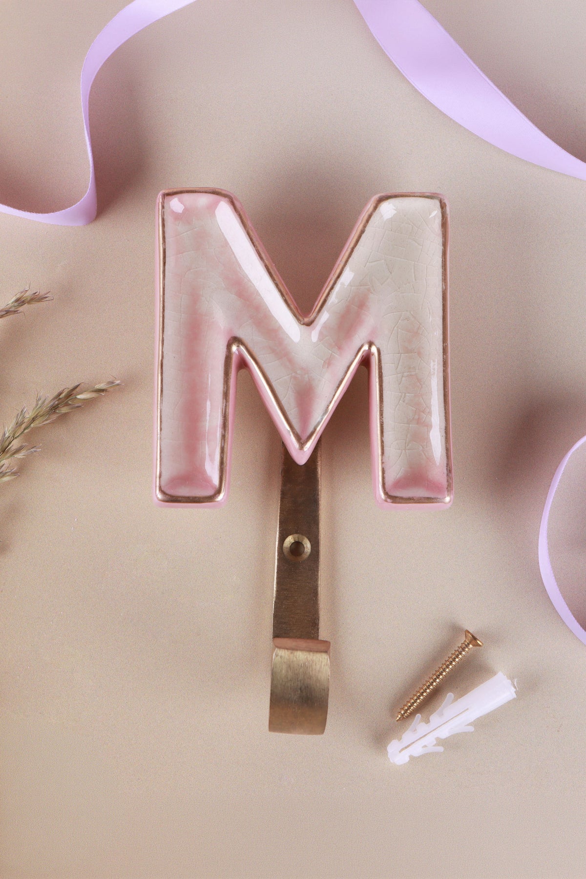 Pink ceramic letter hook M with a gold rim