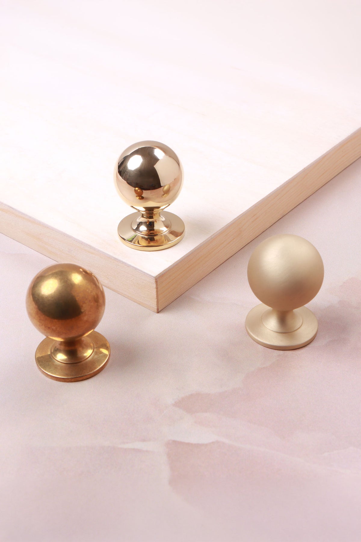 Round cabinet knob in polished, aged and satin brass