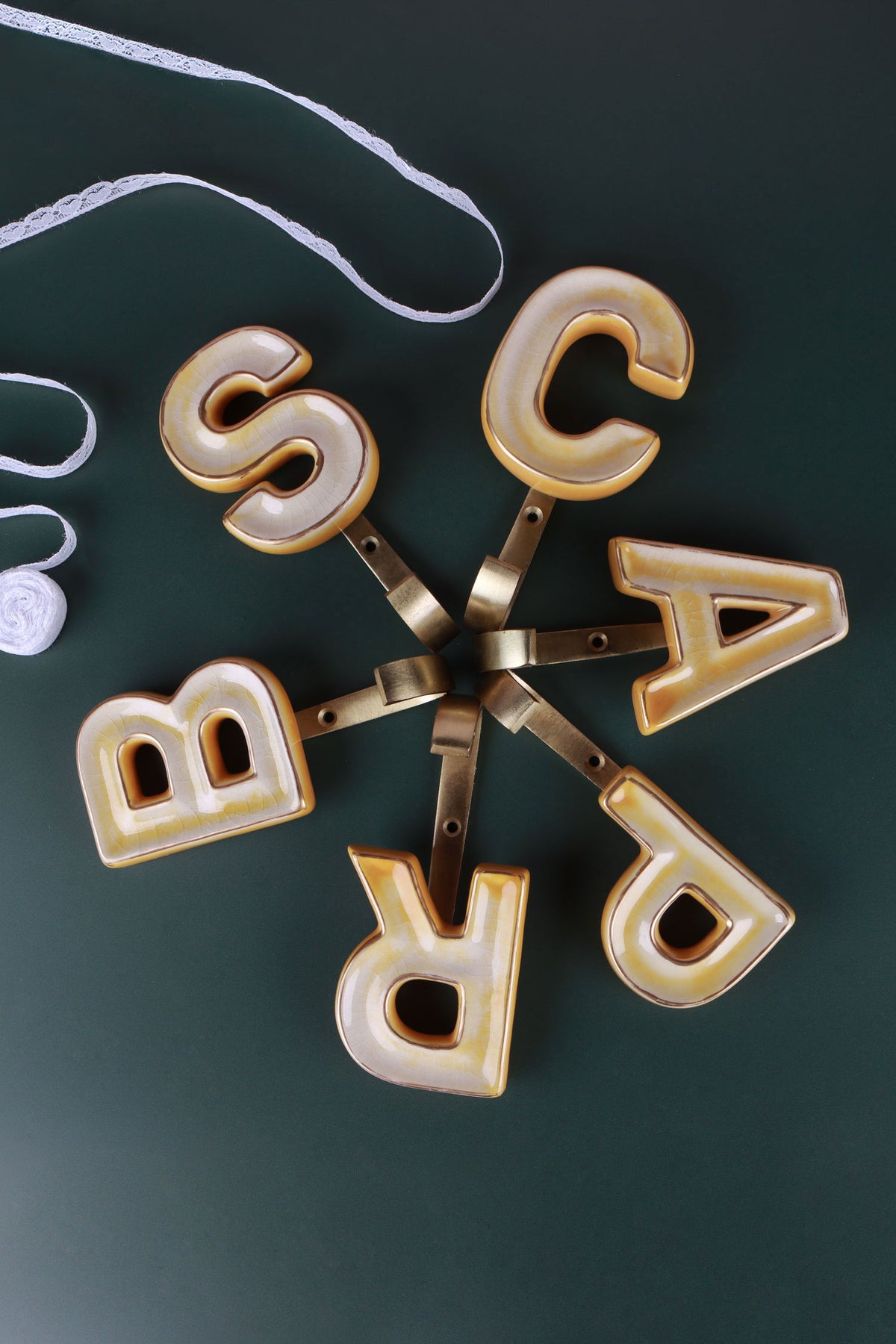 Yellow ceramic letter hooks on the wall, third view