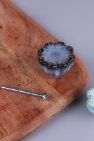 Black speckled ceramic drawer knob with a pale blue-grey face and gold-coloured dots, beside its M4 bolt