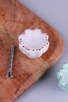 Pale pink scalloped ceramic drawer knob with gold-coloured dots, beside its M4 bolt