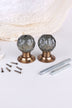 Pair of smokey grey faceted glass mortice door knobs on antique brass roses, with the square spindles and fixing screws