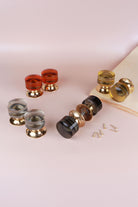 Cylinder glass mortice door knobs in amber, clear crystal, ivory and smokey grey on polished brass roses, the smokey grey pair joined on its spindle, with fixing screws