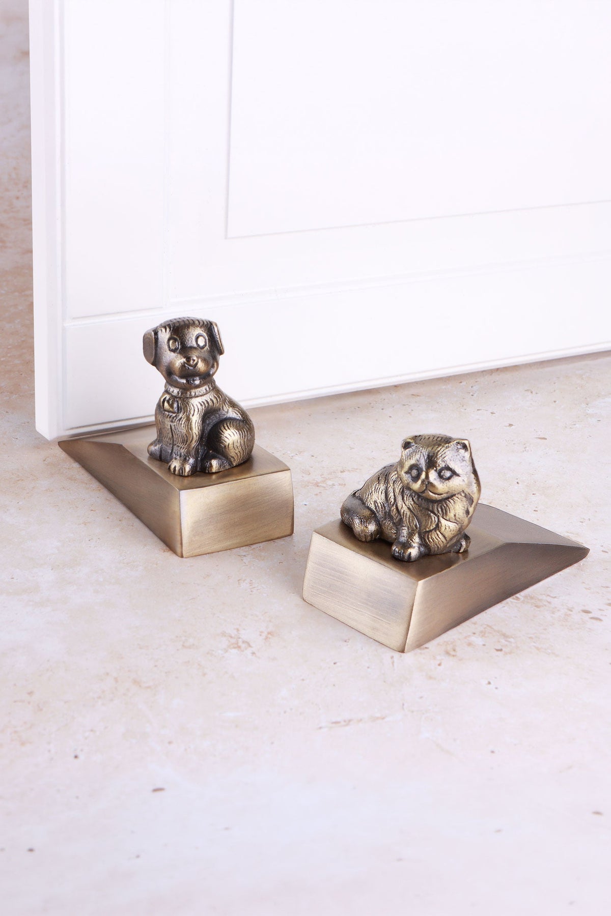 Companion cat and dog door stoppers in antique brass
