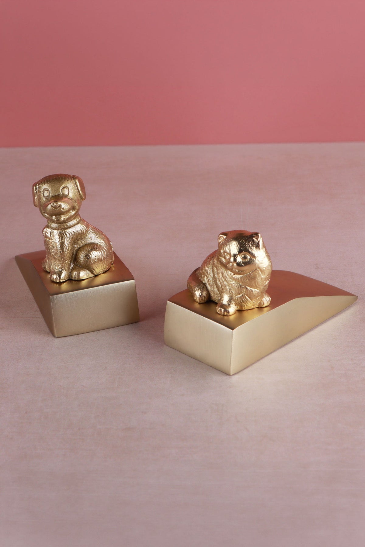 Companion cat and dog door stoppers in polished brass