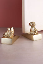 Companion cat and dog door stoppers in polished brass, holding an interior door