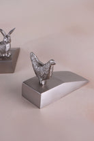Hen door stopper in chrome on a weighted wedge base