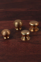 Four solid aged brass cabinet knobs — beehive and victorian, in 32mm and 38mm
