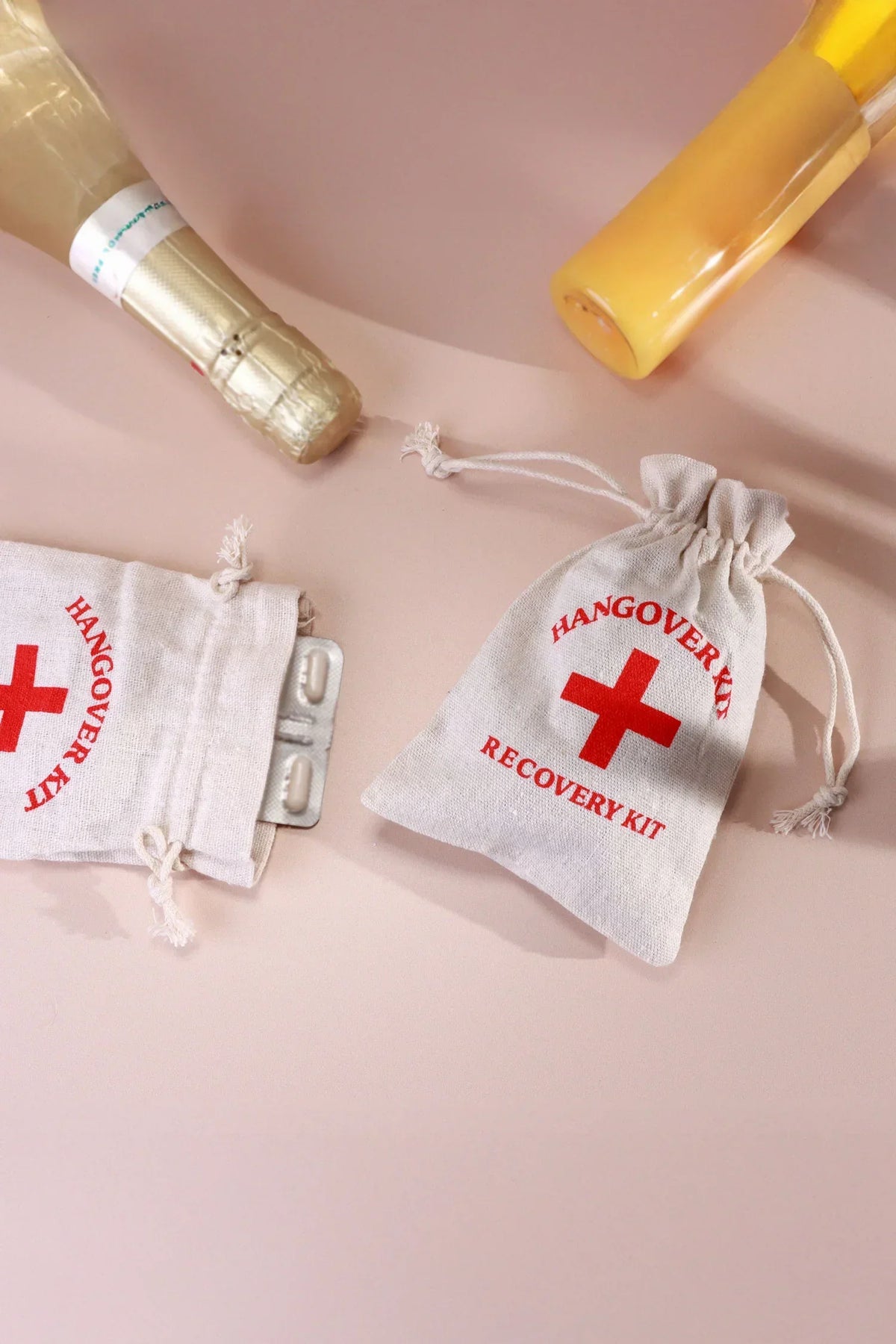 Pair of Hangover Kit Linen Gift Bags with Red Cross Design — lifestyle view, G Decor