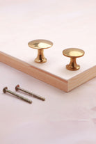 Aged brass flat knobs, 32mm and 38mm, with fixing bolts