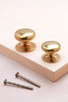 Aged brass Victorian knobs, 32mm and 38mm, with fixing bolts