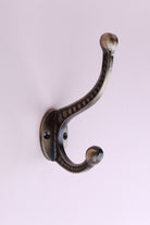 Beaded Double Hook: cast iron double hook with a row of raised beads along both arms and ball ends, on an oval back plate, antique brass finish