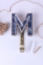 Blue ceramic letter hook M with a gold rim