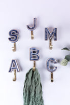 Blue ceramic letter hooks on the wall, third view