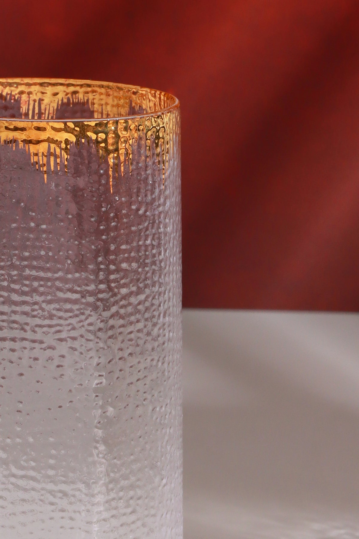 Close-up of the gold splash rim and the hammered texture of the glass