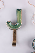 Green ceramic letter hook J with a gold rim