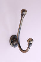 Long Ball Tip Hook: cast iron slim double hook with ball tips, on a round collared back plate, antique brass finish