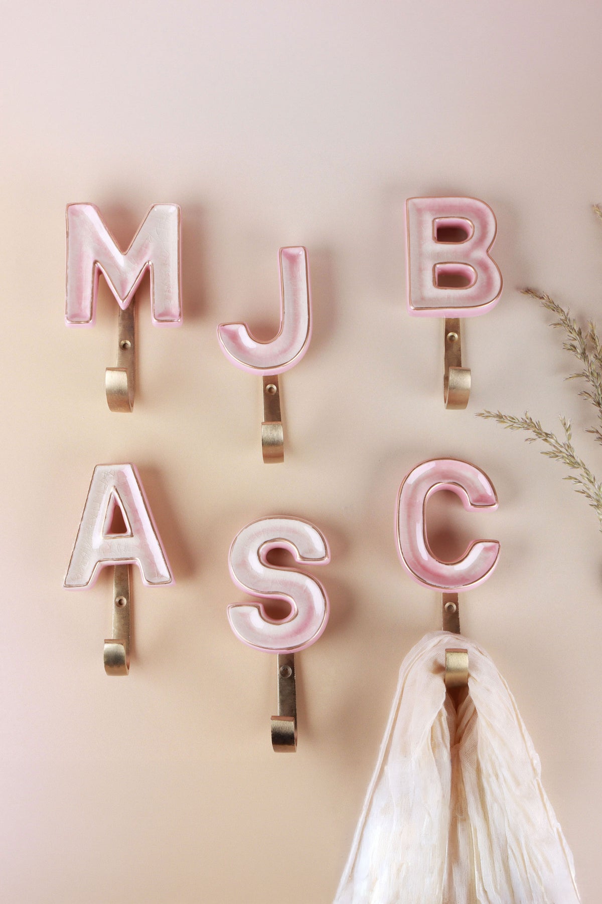 Pink ceramic letter hooks on the wall, third view