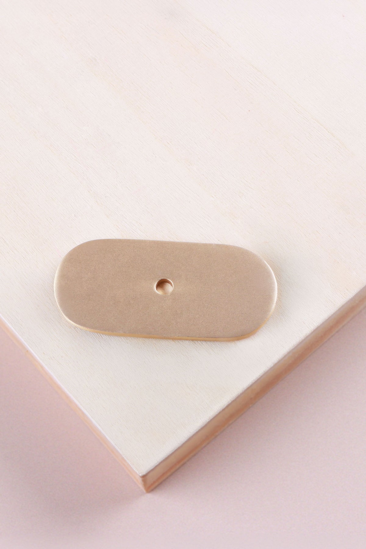 Satin brass oblong backplate, 54 x 25mm with rounded ends: solid brass with a 4mm centre hole for the knob bolt