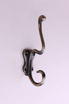 Tall Scroll Hook: cast iron tall S-shaped double hook with scrolled ends, on a long back plate with four screw holes, antique brass finish