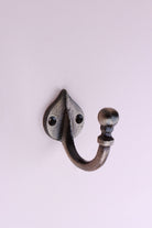 Teardrop Hook: cast iron single hook with a ball end, on a pointed teardrop back plate, antique brass finish