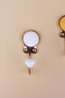 White ceramic coat hook: white disc in a gold-tone frame with a white ceramic knob