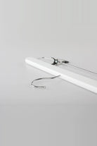 White wooden clip hanger lying flat, showing the metal hook and a clip