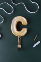 Yellow ceramic letter hook C with a gold rim
