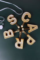 Yellow ceramic letter hooks on the wall, third view