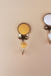 Yellow ceramic coat hook: warm mustard yellow disc in a gold-tone frame with a matching yellow ceramic knob